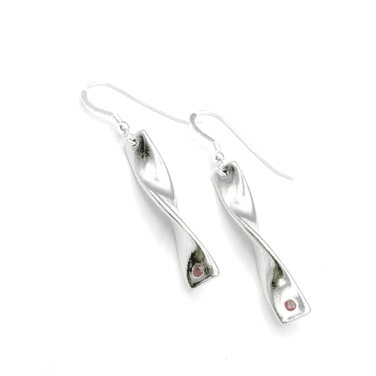 Cornish tin earrings with a twist design and inset rubies on a white background